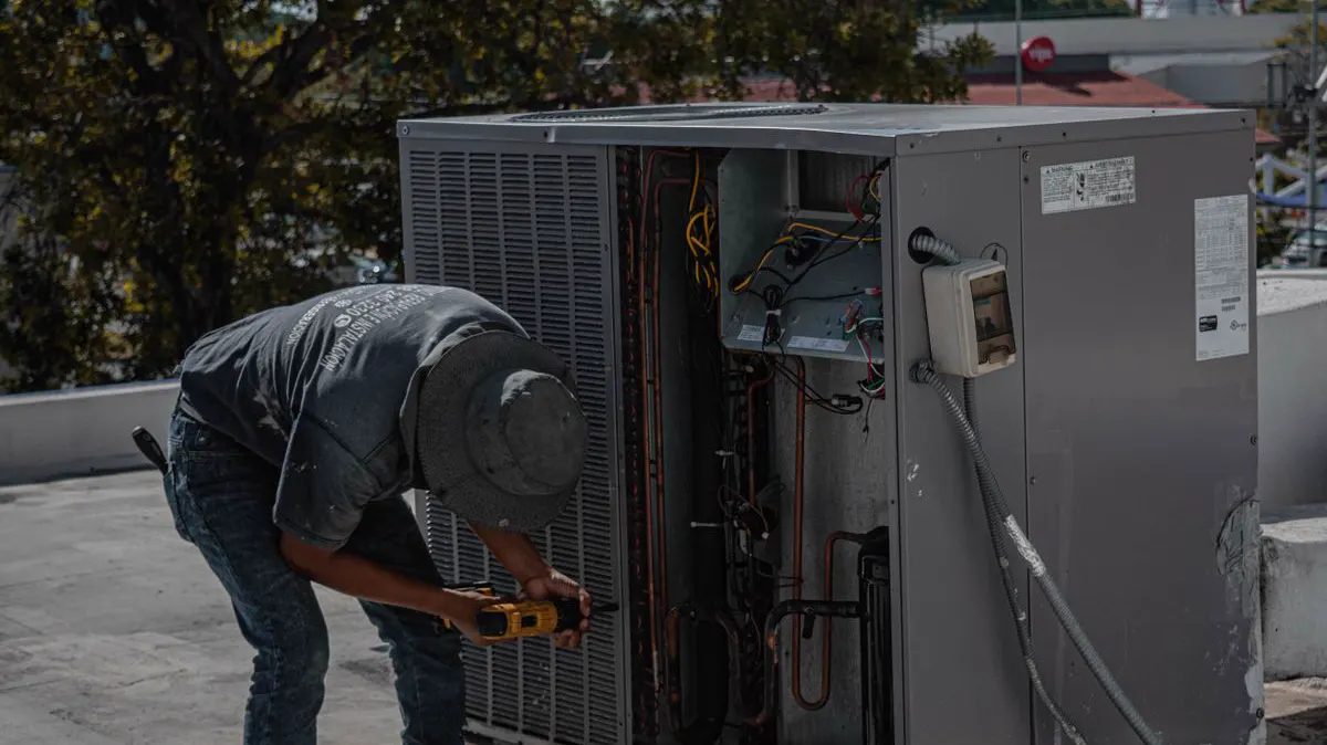 AI receptionist for HVAC companies — technician repairing an outdoor AC unit