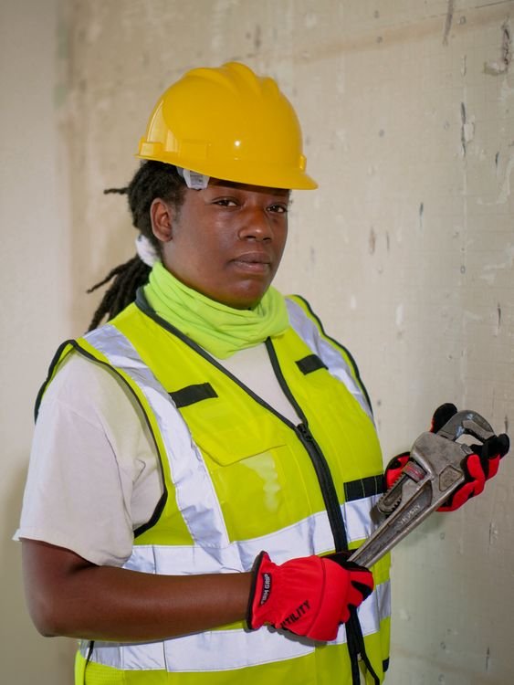 Confident plumbing professional in safety gear holding a wrench — choosing the right AI receptionist for your plumbing business is a trust decision