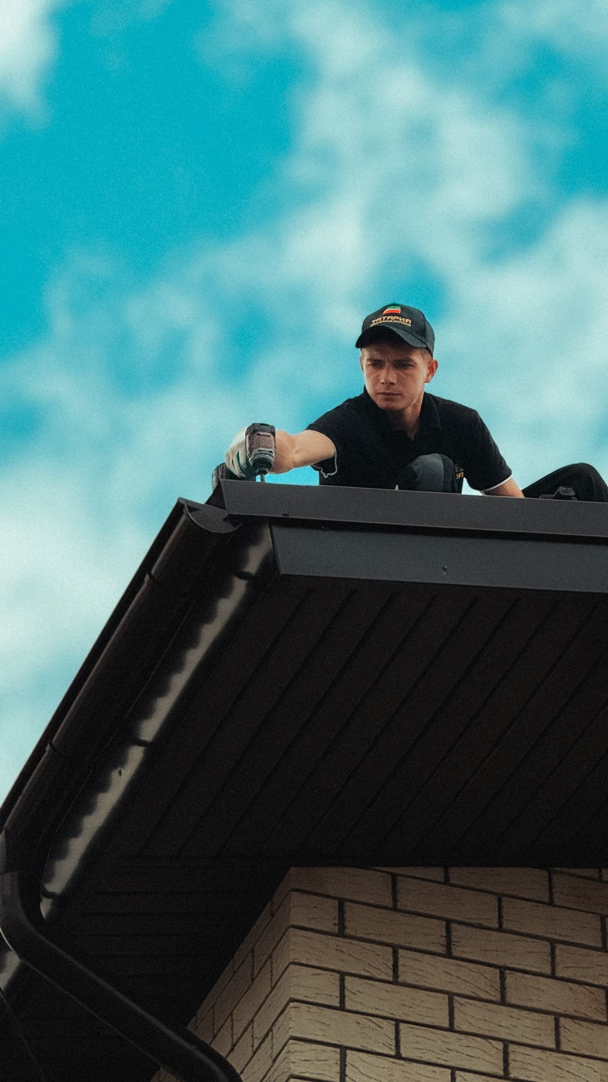 Roofer working on a house roof under a clear sky — an AI receptionist for roofing companies captures every lead while the crew stays on the job